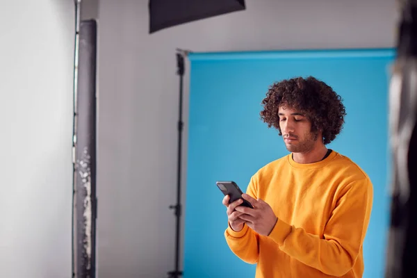 Studio Portrait Jeune Homme Regardant Téléphone Portable Sur Fond Bleu — Photo