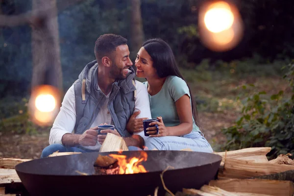 ロマンチックなカップルキャンプは熱い飲み物と火のボウルでたき火で座っている — ストック写真