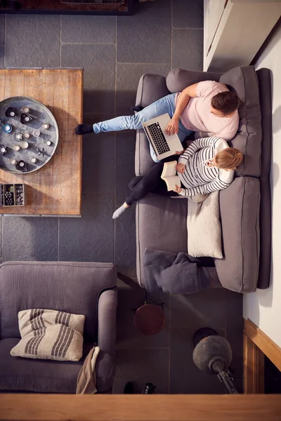 Visão Aérea Casal Relaxando Sofá Salão Casa Livro Leitura Usando — Fotografia de Stock