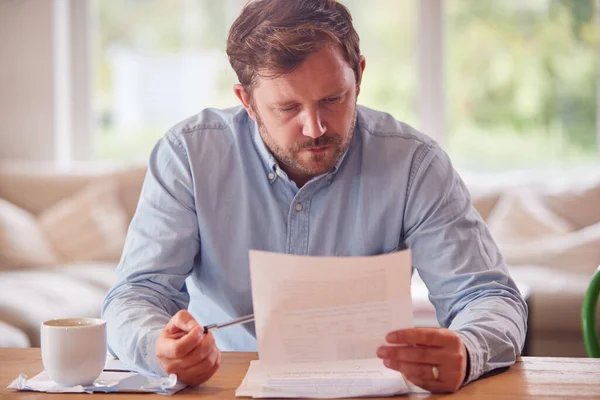 Bezorgde Man Zit Aan Tafel Thuis Binnenlandse Financiën Bekijken — Stockfoto