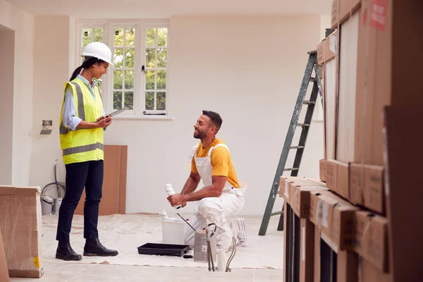 Surveyor Fêmea Com Reunião Digital Comprimido Com Decorador Que Trabalha — Fotografia de Stock