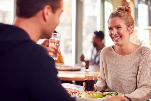 一緒にレストランでピザを楽しむデートで笑顔のカップル — ストック写真