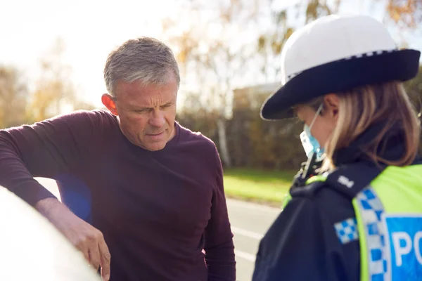 Male Driver Being Stopped By Female Traffic Police Officer For Driving Offence