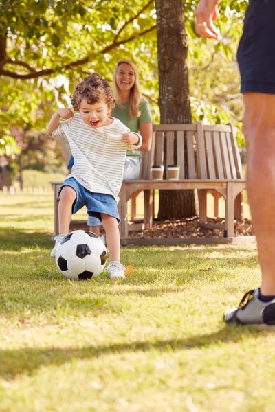 Familia Con Hijo Joven Divirtiéndose Parque Jugando Fútbol Sentado Asiento Imagen de archivo