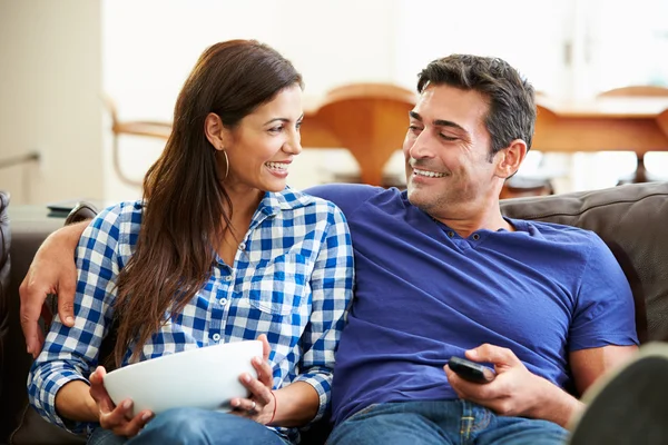 Casal sentado no sofá assistindo TV juntos — Fotografia de Stock