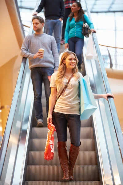 Женщина-покупатель на эскалаторе в торговом центре — стоковое фото