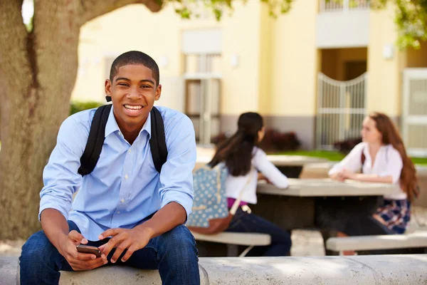 Estudiante usando teléfono en el campus escolar — Foto de Stock