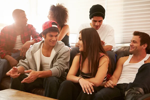 Группа молодых людей, сидящих на диване и разговаривающих — стоковое фото