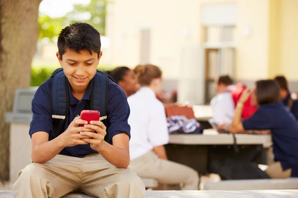 Student pomocí telefonu na školní areál — Stock fotografie