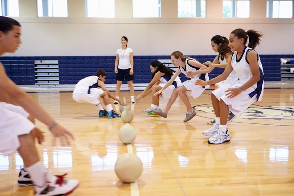 Estudantes jogando Dodge Ball no ginásio — Fotografia de Stock