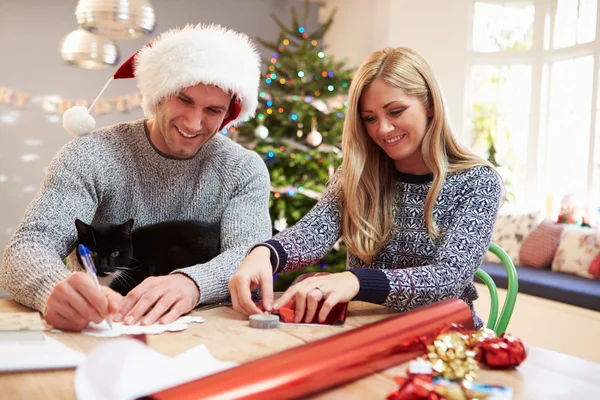 Pareja envolviendo regalos de Navidad en casa —  Fotos de Stock