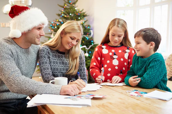 Familia escribiendo tarjetas de Navidad juntos — Foto de Stock