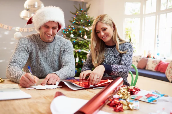 Paar inwikkeling giften van Kerstmis thuis — Stockfoto