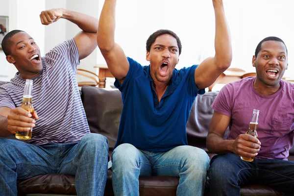 Grupo de homens sentados no sofá assistindo TV juntos — Fotografia de Stock