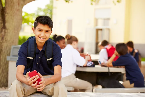 Student pomocí telefonu na školní areál — Stock fotografie