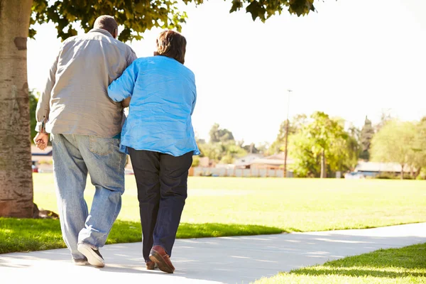 Anziana donna aiutare marito come essi passeggiata in parco insieme — Foto Stock