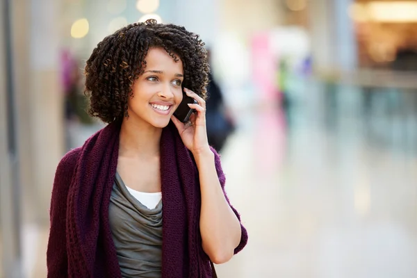 Vrouw In winkelcentrum met behulp van mobiele telefoon — Stockfoto