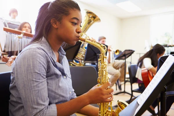 Vrouwelijke leerling spelen saxofoon — Stockfoto