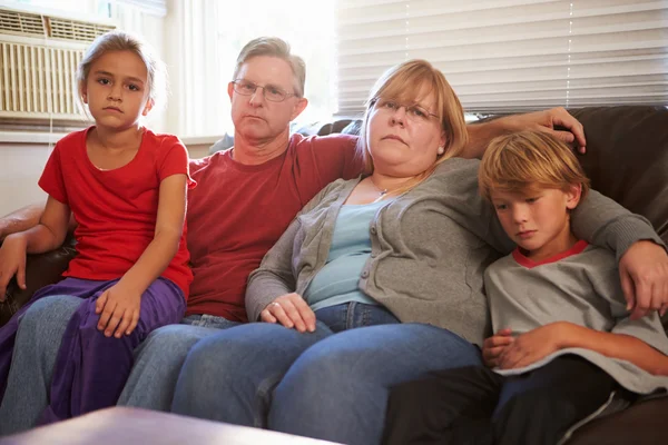 Nešťastná rodina sedí na pohovce — Stock fotografie