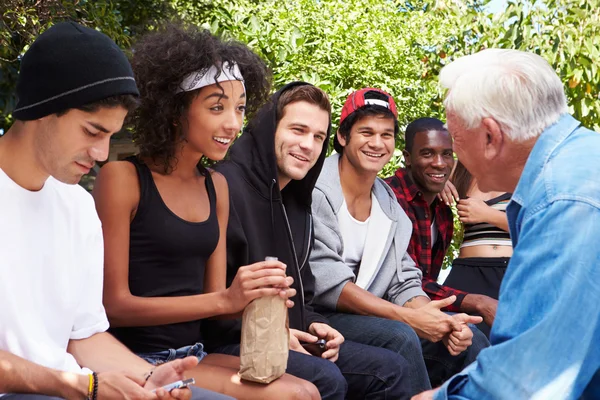 Homem sênior conversando com jovens — Fotografia de Stock