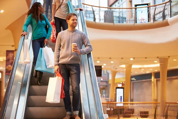 Comprador masculino en escalera mecánica en el centro comercial —  Fotos de Stock