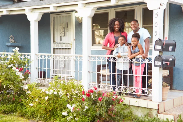 Retrato de la familia de pie en el porche de la casa suburbana — Foto de Stock