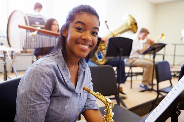 Vrouwelijke leerling spelen saxofoon — Stockfoto