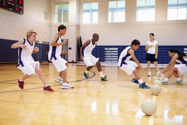 Estudantes jogando Dodge Ball no ginásio — Fotografia de Stock