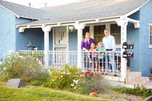 Retrato de la familia de pie en el porche de la casa suburbana —  Fotos de Stock