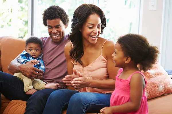 Jovem família relaxante no sofá — Fotografia de Stock