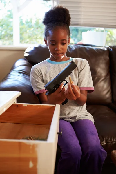 Flicka som leker med förälderns pistol — Stockfoto
