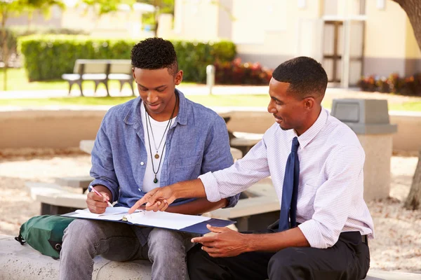 Lärare att hjälpa manlig student med arbete — Stockfoto