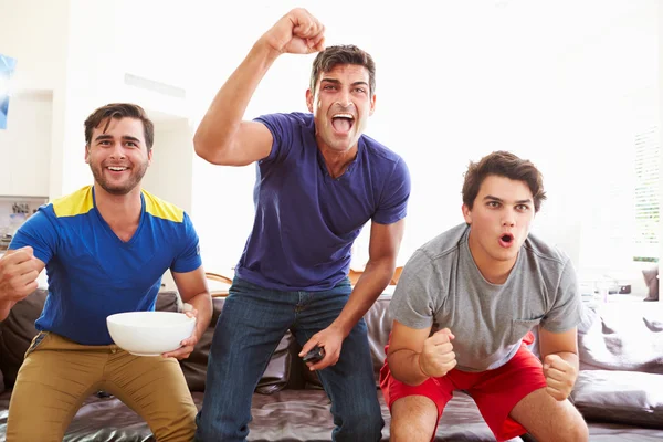 Gruppo di uomini seduti sul divano a guardare lo sport insieme — Foto Stock