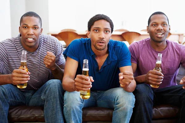 Grupo de homens sentados no sofá assistindo TV juntos — Fotografia de Stock