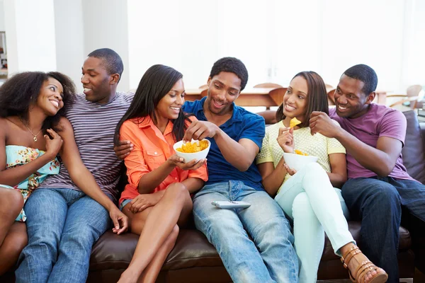 Groep vrienden zittend op de Bank samen tv kijken — Stockfoto