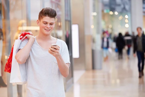 Hombre en el centro comercial usando el teléfono móvil —  Fotos de Stock