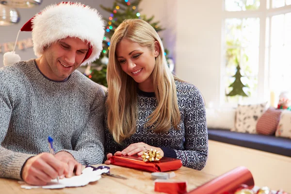 Pareja envolviendo regalos de Navidad en casa — Foto de Stock