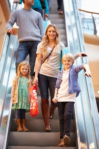 Madre e hijos en escalera mecánica en el centro comercial —  Fotos de Stock