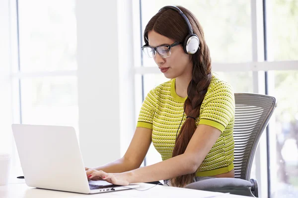 Mulher usando fones de ouvido trabalhando — Fotografia de Stock