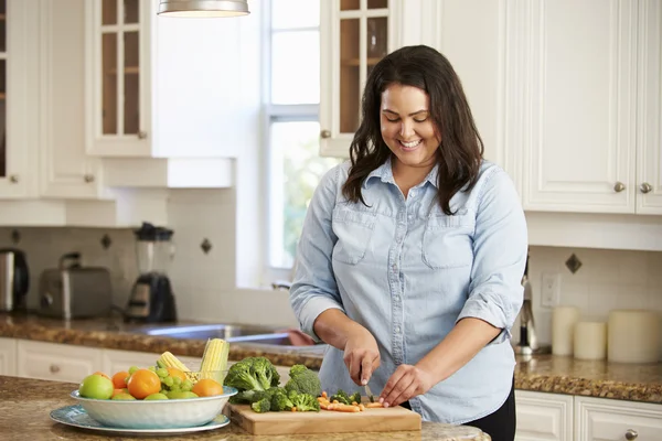 Übergewichtige Frau bereitet Gemüse zu — Stockfoto