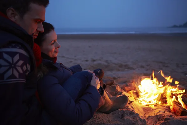Para siedzi przez ogień — Zdjęcie stockowe