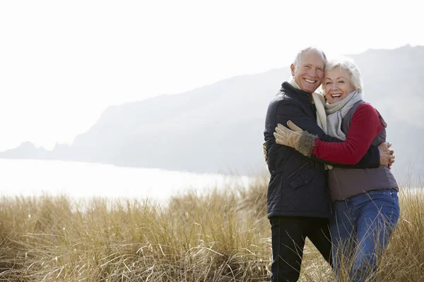 Seniorenpaar spaziert auf Dünen — Stockfoto