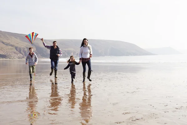 Familia corriendo con cometa voladora —  Fotos de Stock