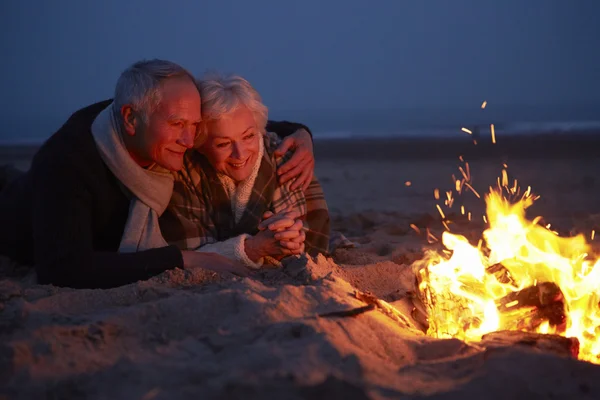 Äldre par sittande vid brand — Stockfoto