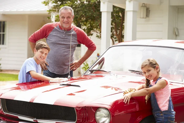 Grootvader met kleinkinderen schoonmaken auto — Stockfoto
