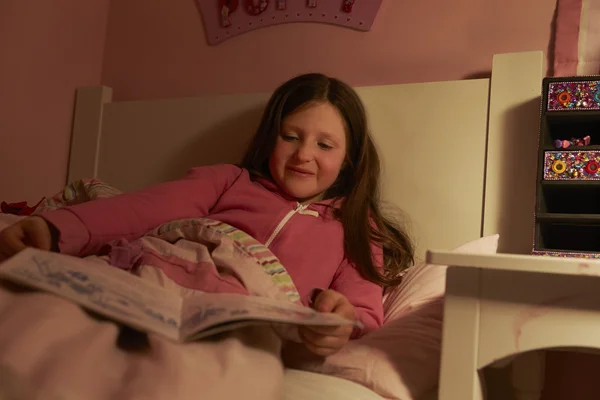 Chica leyendo libro en la cama — Foto de Stock