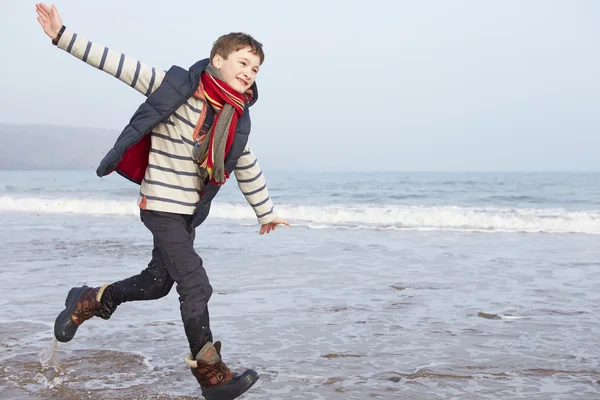 Junge rennt am Strand entlang — Stockfoto