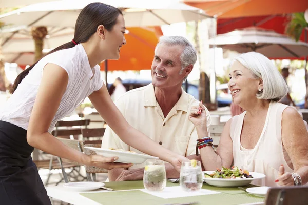 Camarera sirviendo almuerzo de pareja mayor — Foto de Stock