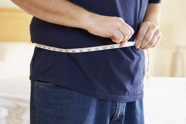 Hombre con sobrepeso que mide la cintura — Foto de Stock