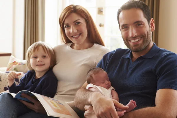 Familia sentada en sofá con bebé recién nacido — Foto de Stock